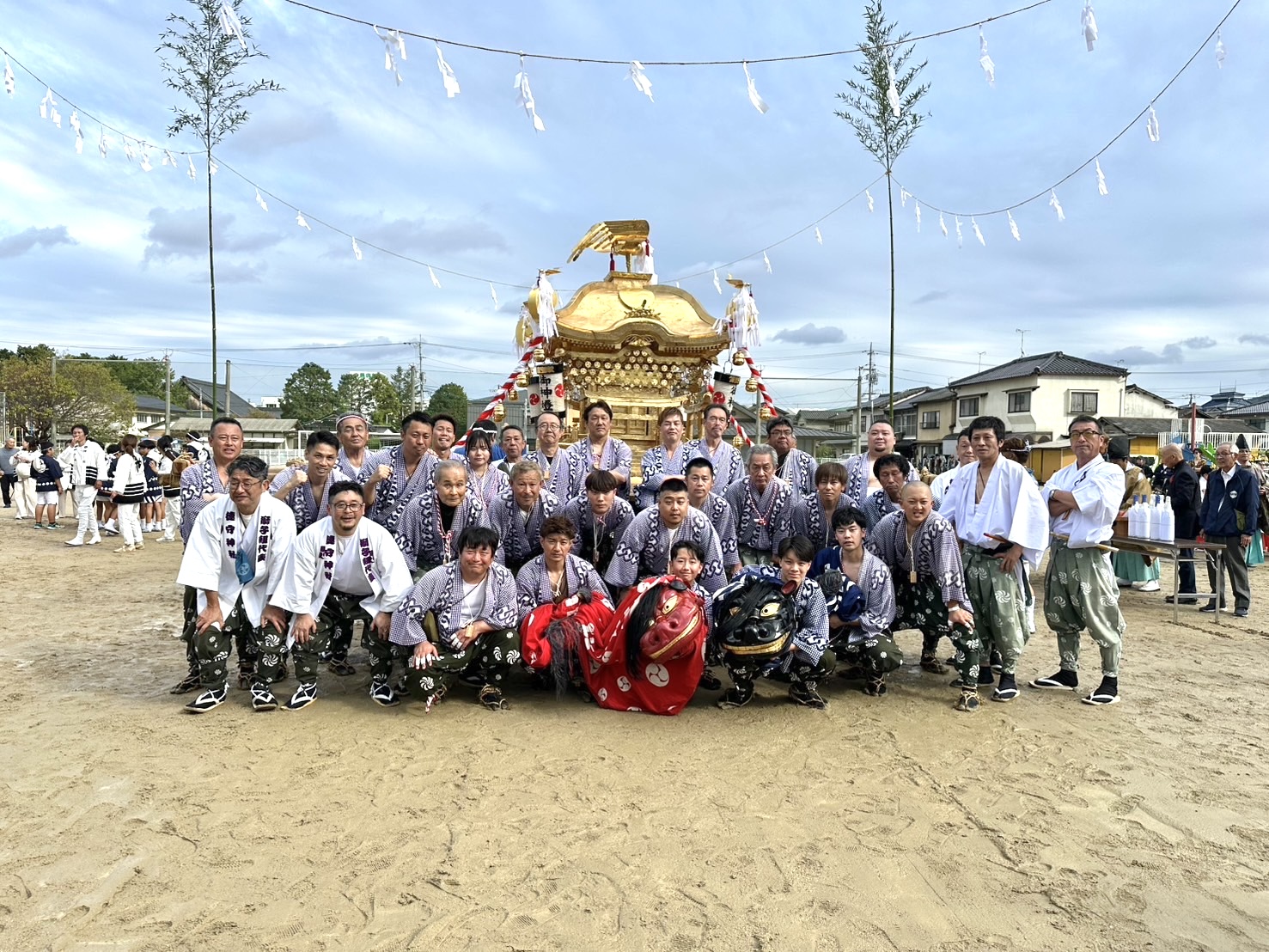 金色のお神輿と赤・黒の獅子を囲む、神田の皆さんの集合写真